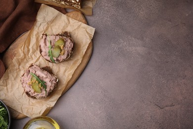 Photo of Delicious liverwurst sandwiches with pickled cucumber and mustard on grey table, top view. Space for text