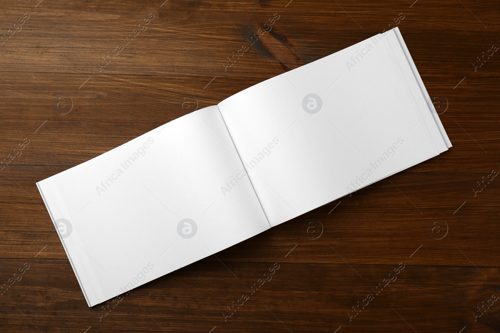 Photo of Open blank paper brochure on wooden table, top view. Mockup for design