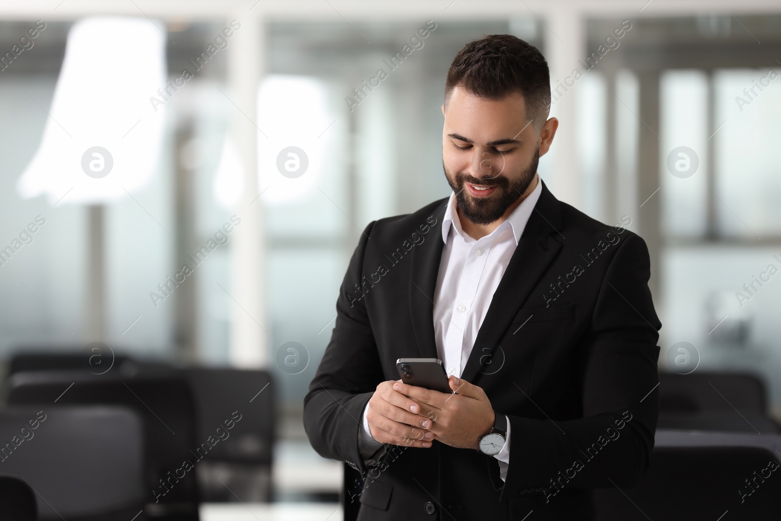 Photo of Smiling man with smartphone in office, space for text. Lawyer, businessman, accountant or manager