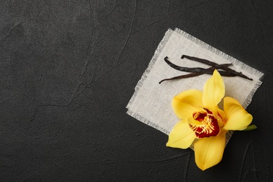 Photo of Vanilla flower and sticks on dark background