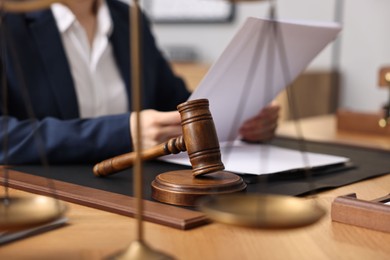 Notary reading document at table in office, focus on gavel