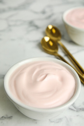 Photo of Tasty organic yogurt on white marble table