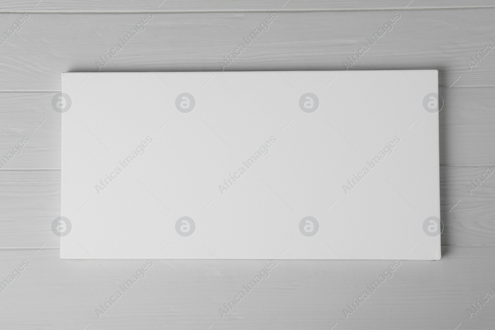 Photo of Blank canvas on white wooden background, space for text
