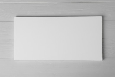 Photo of Blank canvas on white wooden background, space for text