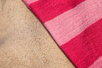 Photo of Soft pink beach towel on sand, above view. Space for text