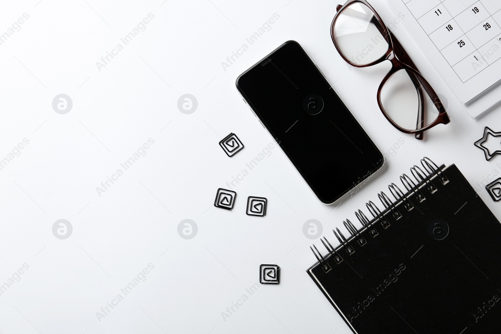 Photo of Composition with notebook, glasses and mobile phone on white background, top view