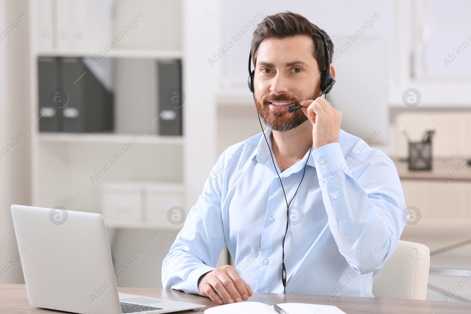 Photo of Hotline operator with headset working in office