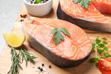 Photo of Fresh salmon and ingredients for marinade on wooden board, closeup