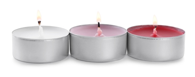 Photo of Burning decorative wax candles on white background