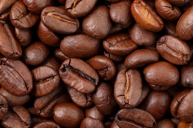 Aromatic roasted coffee beans as background, top view