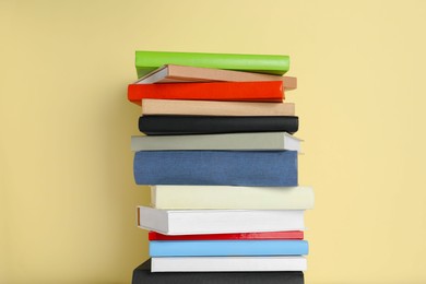 Stack of different books on beige background