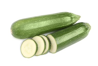 Photo of Whole and cut ripe zucchinis on white background, top view