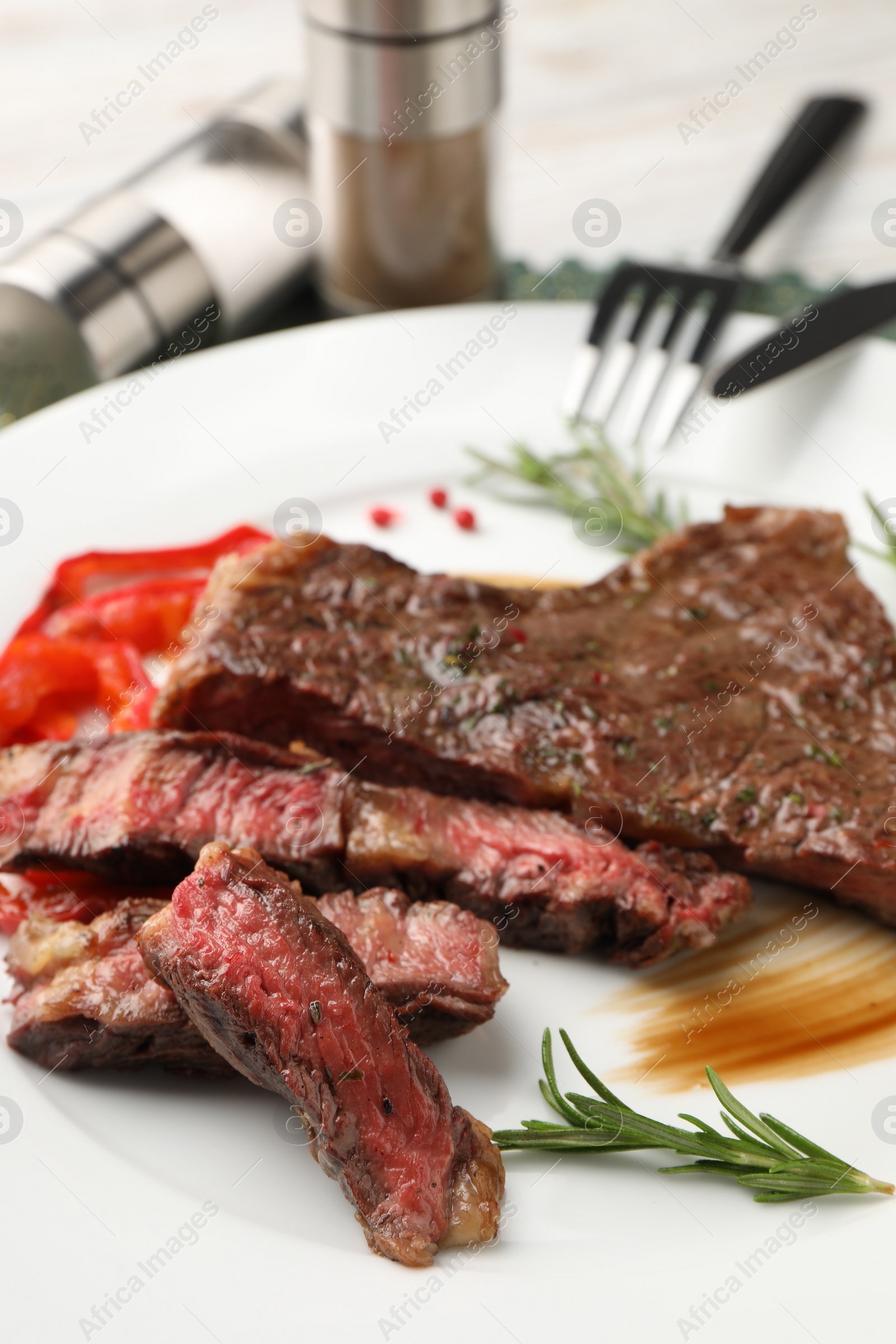 Photo of Delicious grilled beef steak with spices on plate, closeup