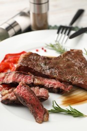 Delicious grilled beef steak with spices on plate, closeup