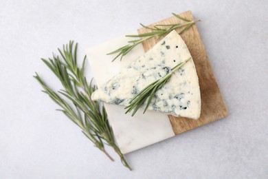 Photo of Tasty blue cheese with rosemary on light table, flat lay