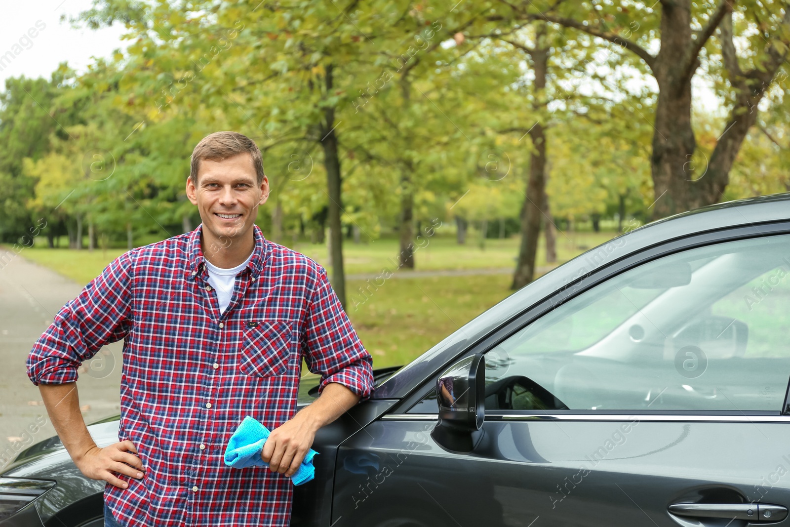 Photo of Man with rug near washed car outdoors