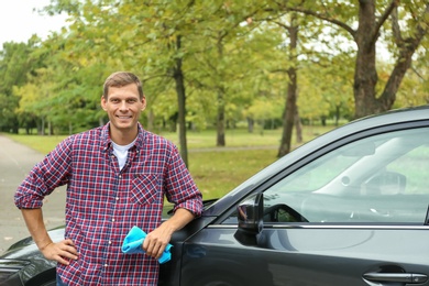 Photo of Man with rug near washed car outdoors