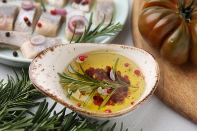 Tasty fish marinade with rosemary on light table, closeup