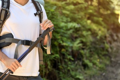 Photo of Hiker with trekking poles in forest, closeup