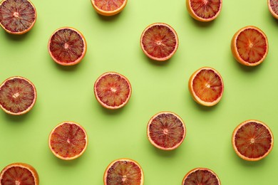Many ripe sicilian oranges on light green background, flat lay
