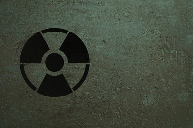 Radioactive sign on stone wall, space for text. Hazard symbol