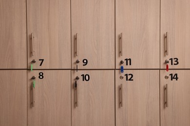 Photo of Many wooden lockers with keys and numbers on doors