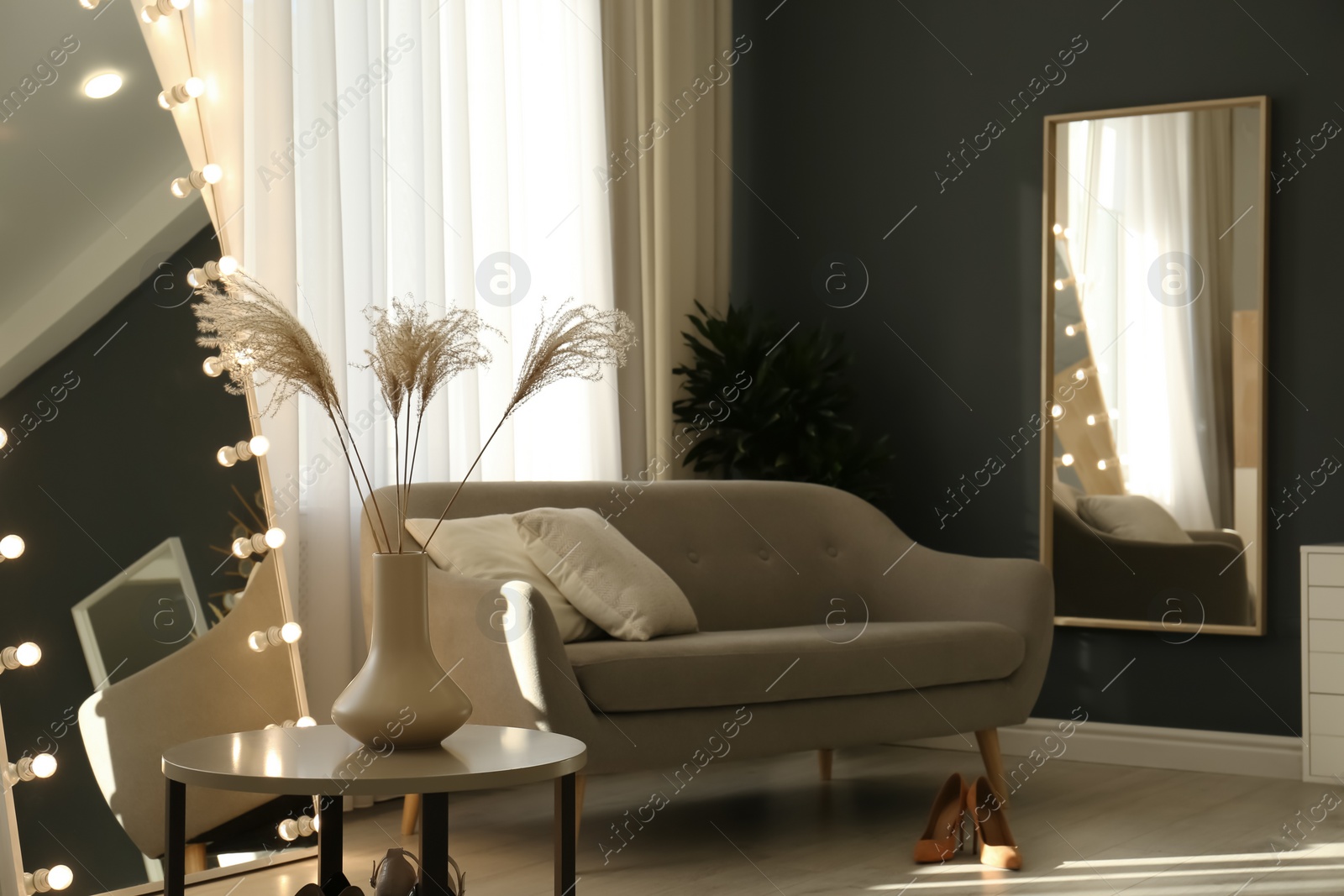 Photo of Vase with dry plants on table in living room. Interior design