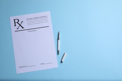 Medical prescription form and pen on light blue background, top view. Space for text