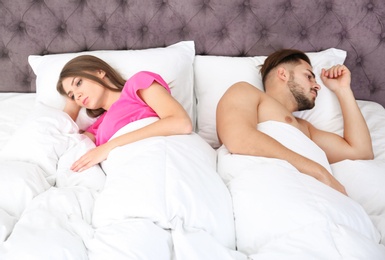 Photo of Upset young couple with relationship problems in bedroom