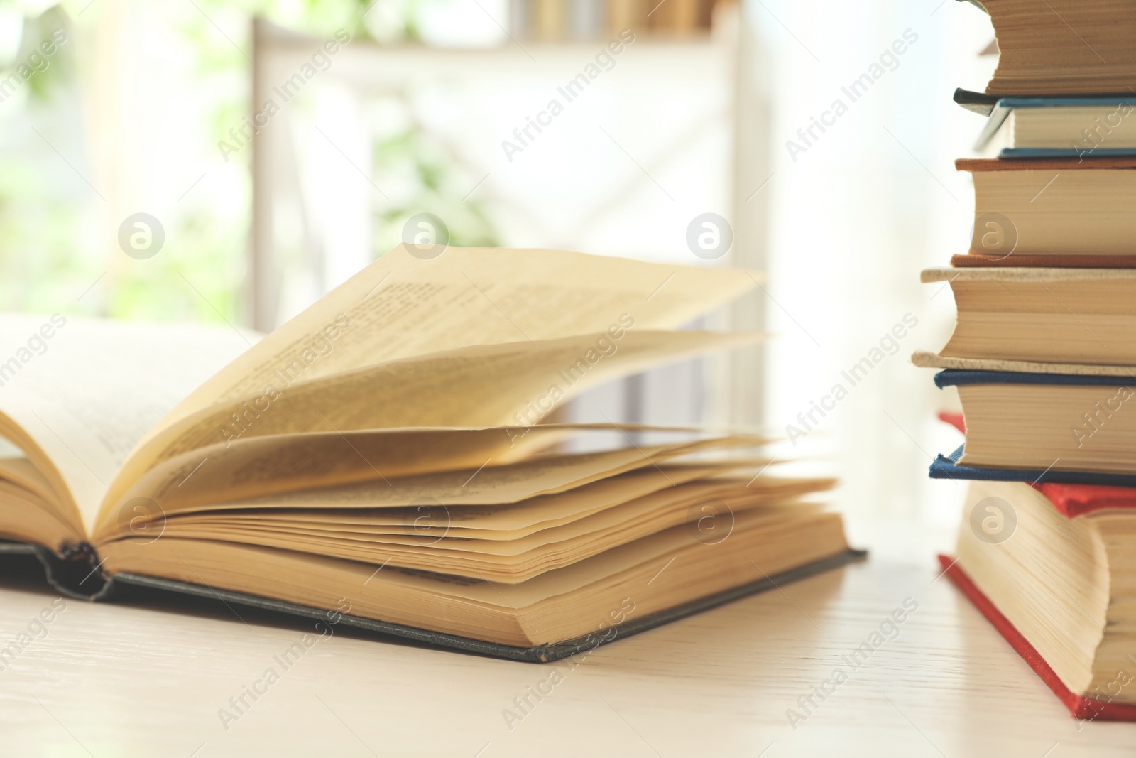 Photo of Open hardcover book on white wooden table indoors