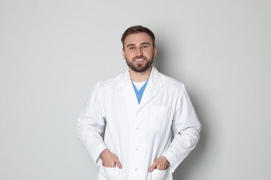 Portrait of young doctor on light grey background