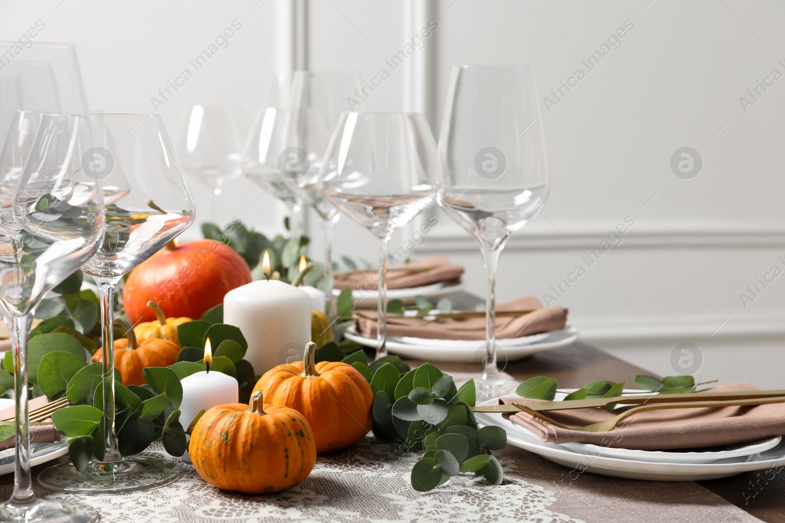 Photo of Beautiful autumn table setting. Plates, cutlery, glasses, pumpkins and floral decor