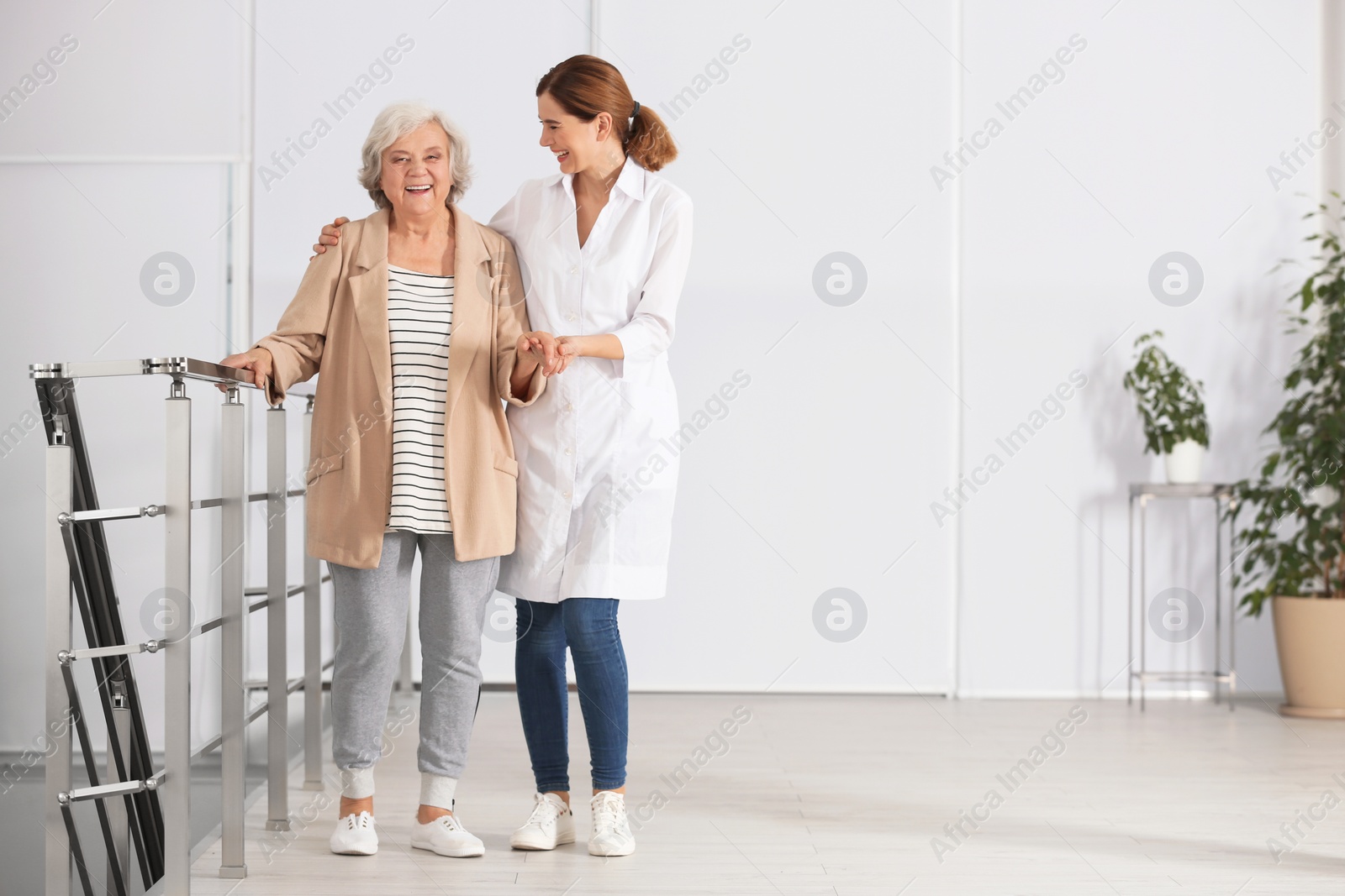 Photo of Elderly woman with caregiver indoors. Space for text