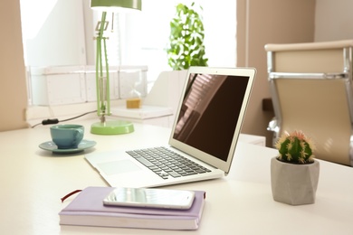 Stylish workplace with laptop on table