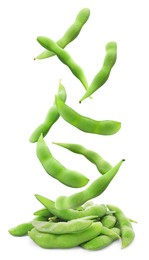 Raw green edamame pods falling onto pile against white background