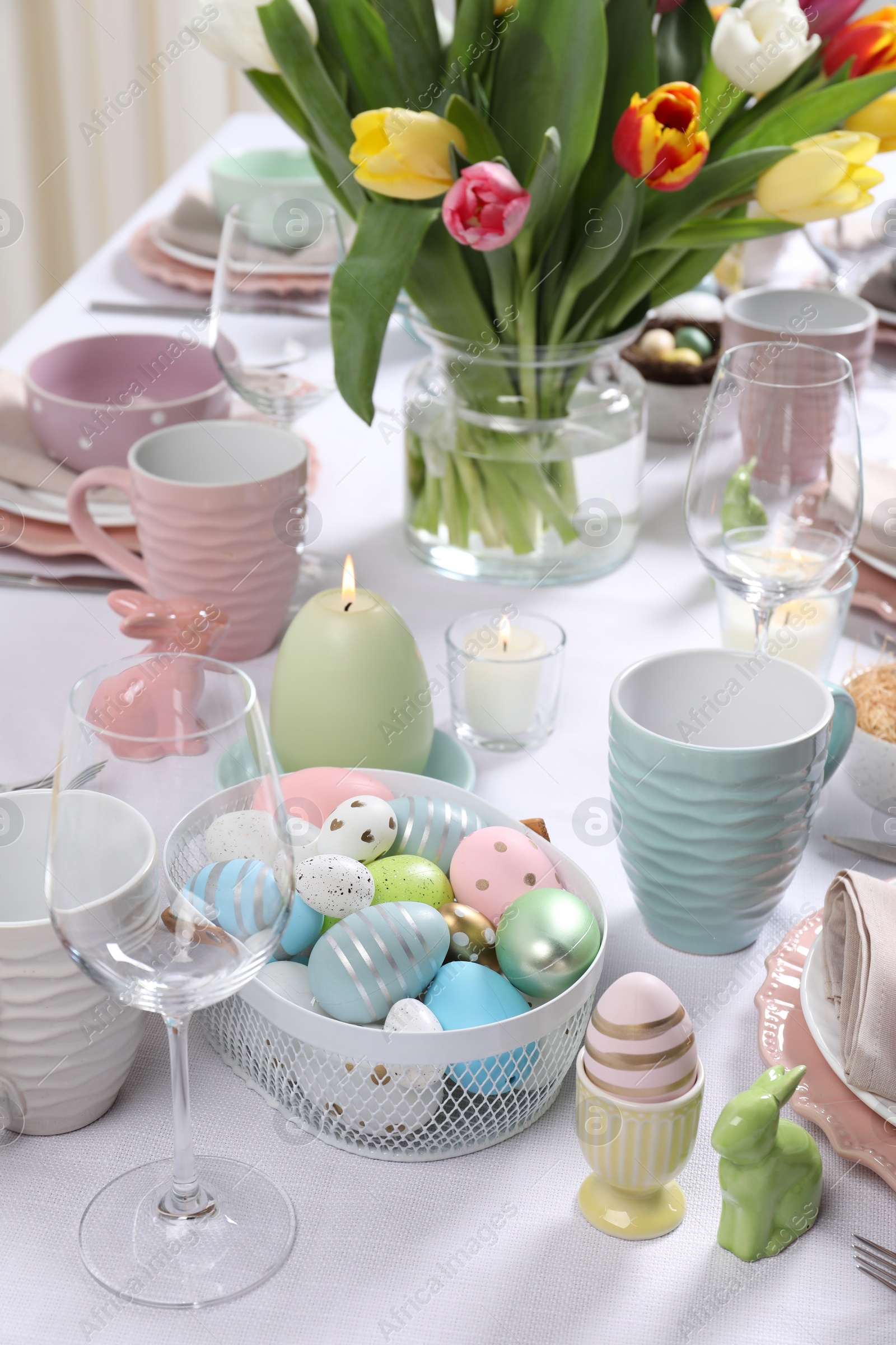 Photo of Festive table setting with painted eggs. Easter celebration