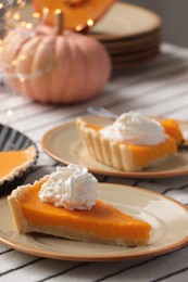 Photo of Fresh homemade pumpkin pie with whipped cream on table