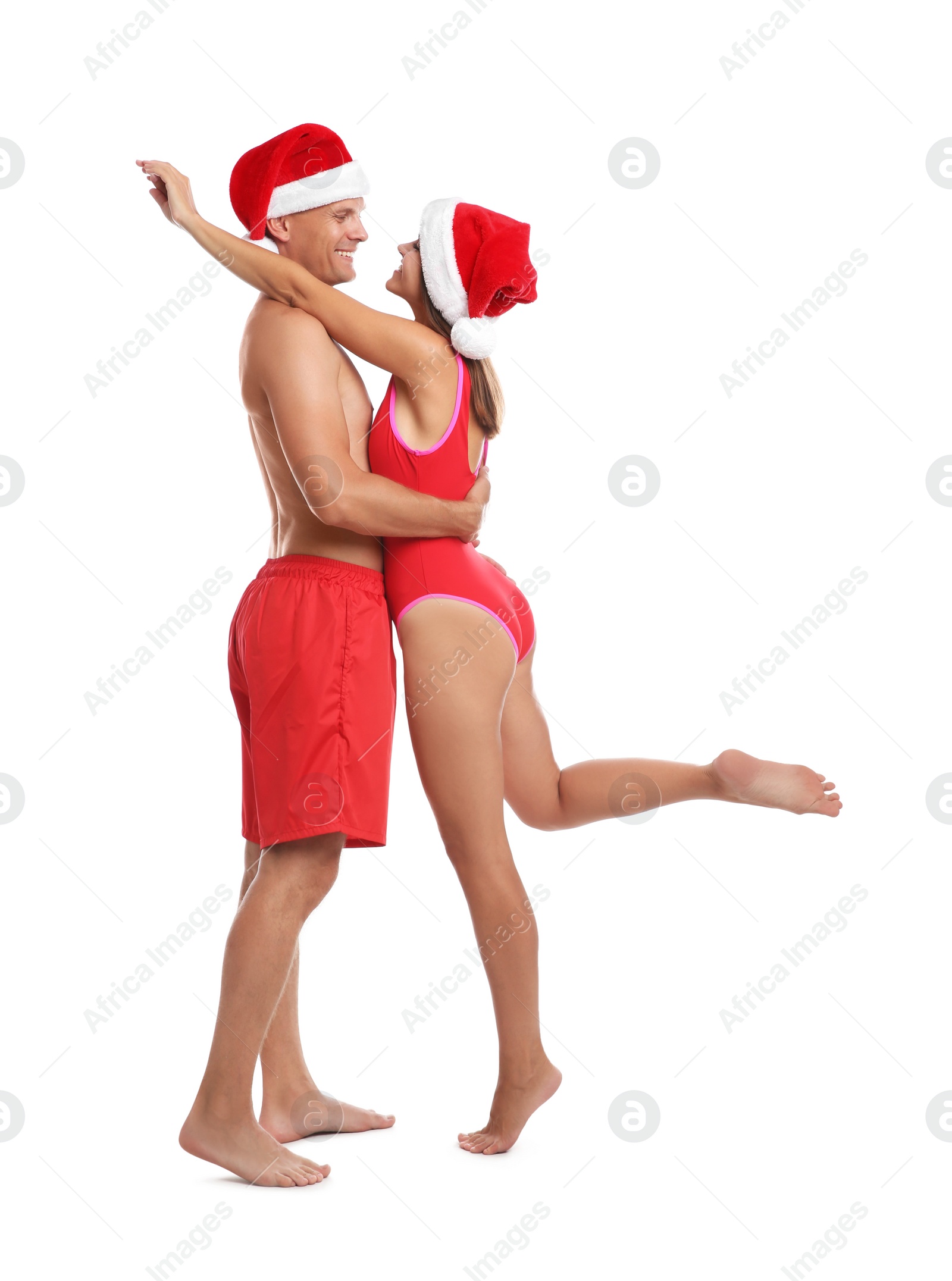 Photo of Happy couple with Santa hats together on white background. Christmas vacation