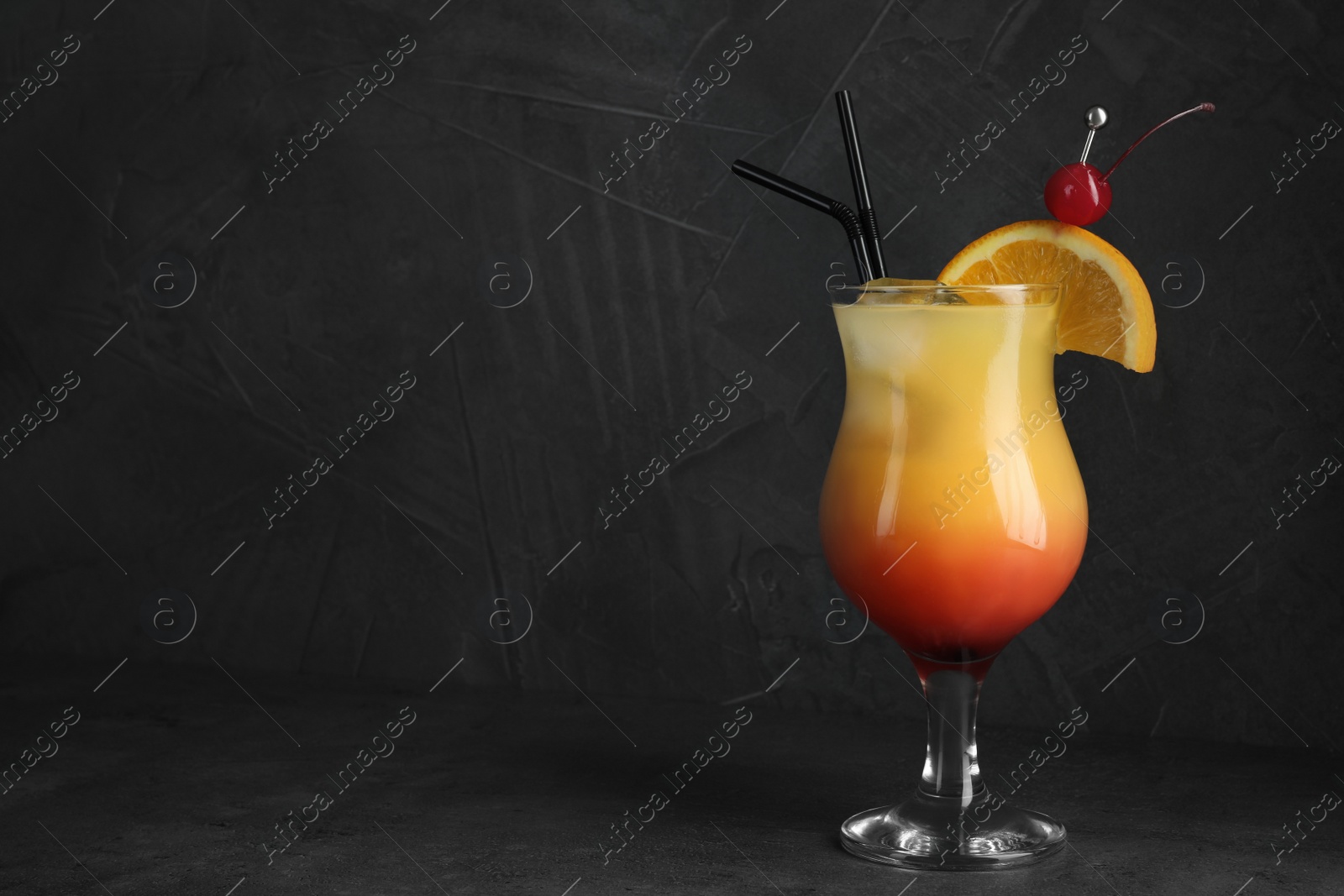 Photo of Just made appetizing cocktail Sex on the Beach, black background. Space for text