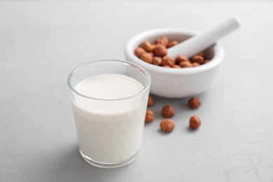 Glass with hazelnut milk on light background