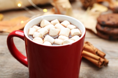 Cup of hot drink on wooden table, closeup. Cozy autumn atmosphere