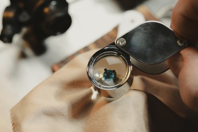 Photo of Professional jeweler working with gemstone, closeup view