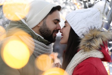 Happy young couple spending time together at winter fair. Christmas celebration