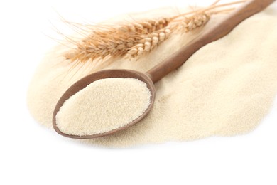 Photo of Spoon with semolina and spikelets on white background