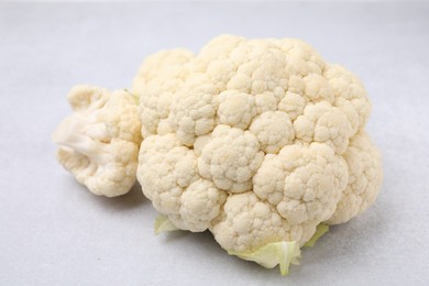 Photo of Cut fresh raw cauliflower on light grey table