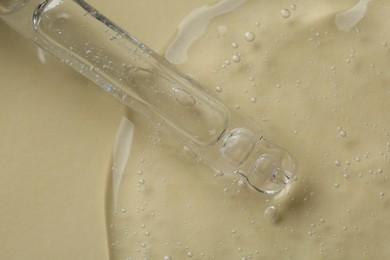 Photo of Pipette with cosmetic serum on beige background, above view