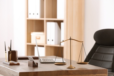 Table with scales of justice in lawyer's office