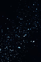 Photo of Snow flakes falling on black background. Winter weather