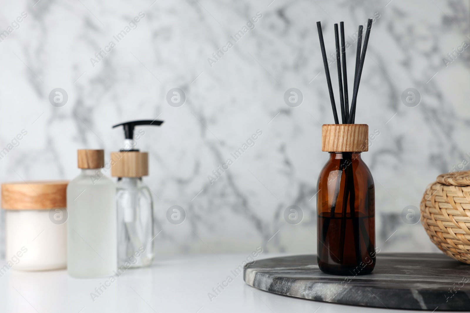 Photo of Air reed freshener and cosmetic products on white table. Space for text