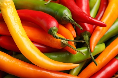 Different ripe chili peppers as background, closeup